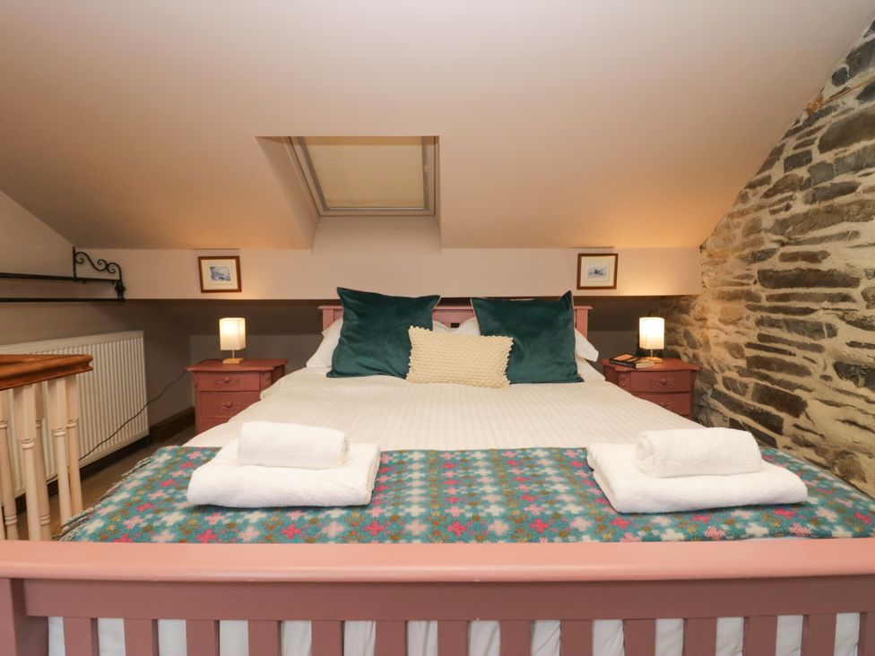 A bedroom with a bed and nightstands at Corner Cottage Lowick Green near Ulverston