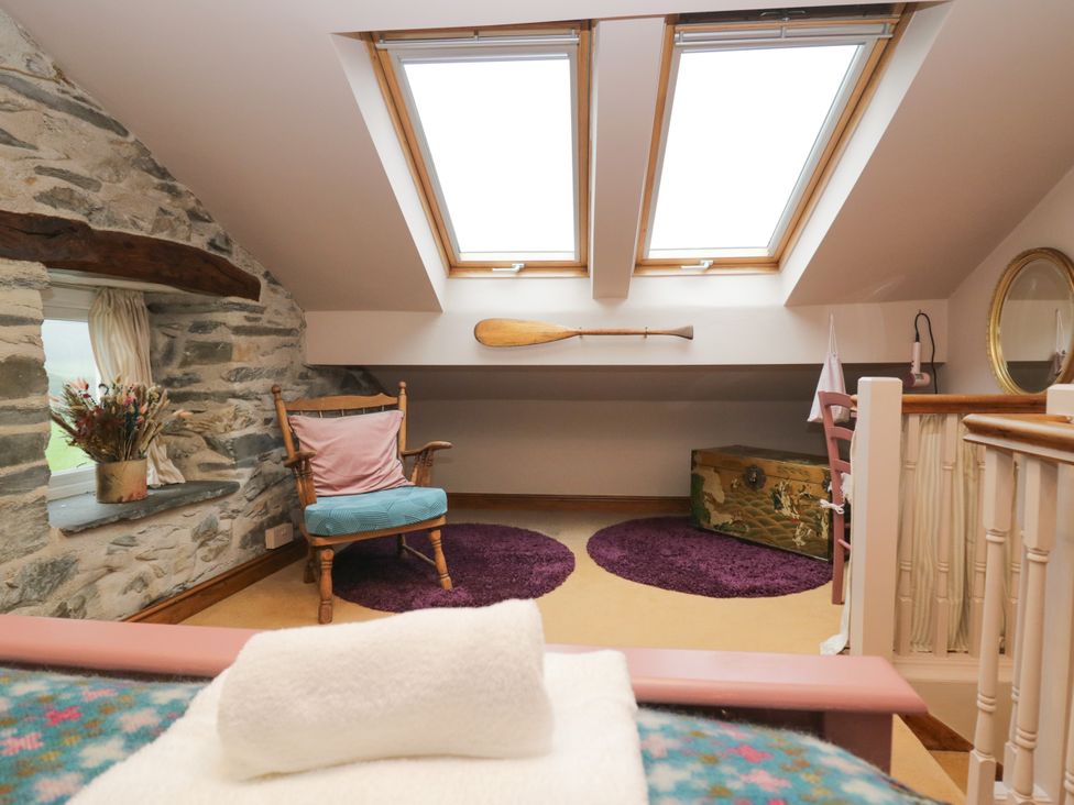 A loft with skylights and a chair at Corner Cottage Lowick Green near Ulverston