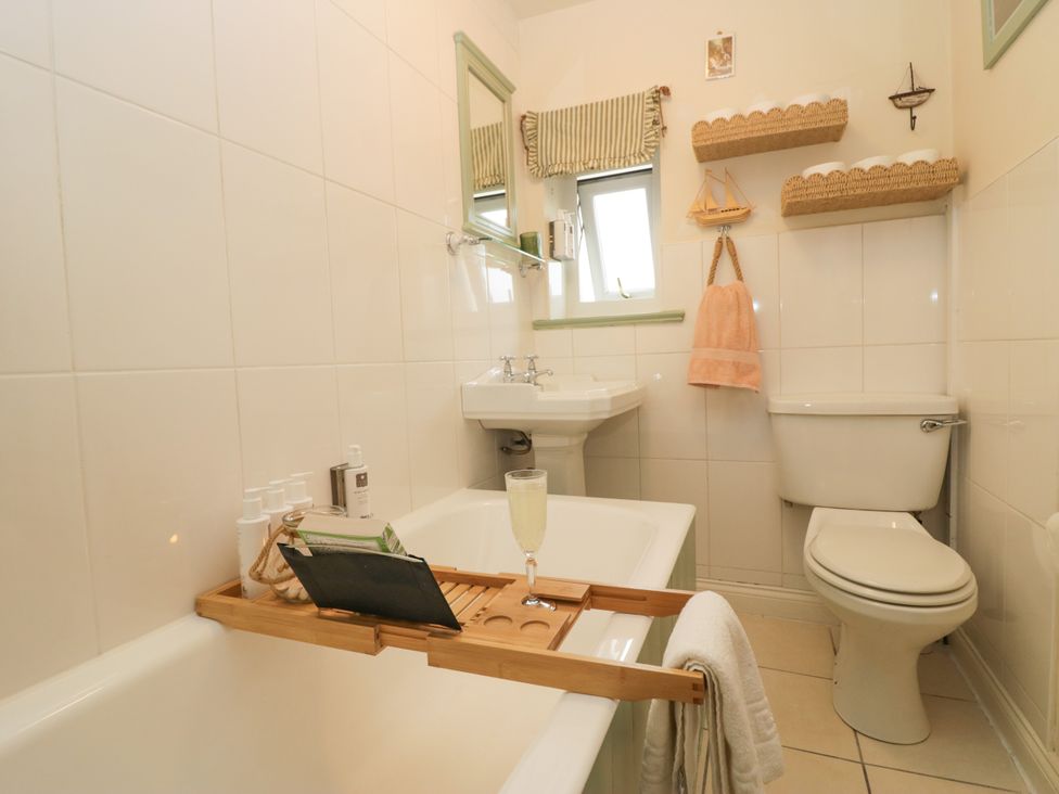 A bathroom with a bathtub and sink at Corner Cottage in Lowick Green near Ulverston