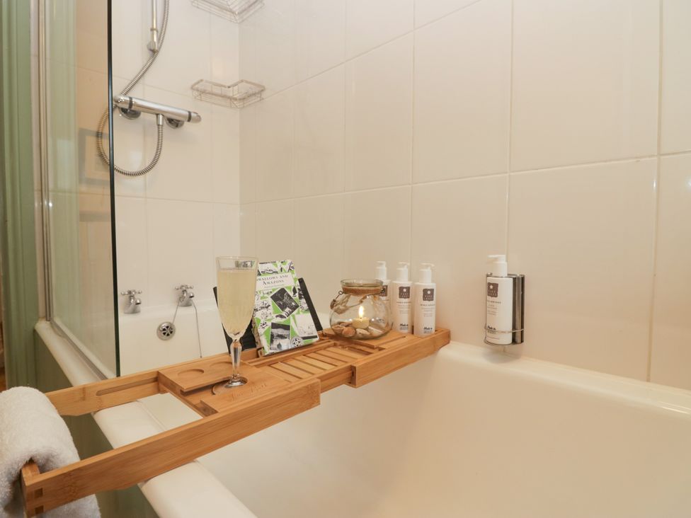 A bathroom with a bathtub and shower at Corner Cottage in Lowick Green near Ulverston