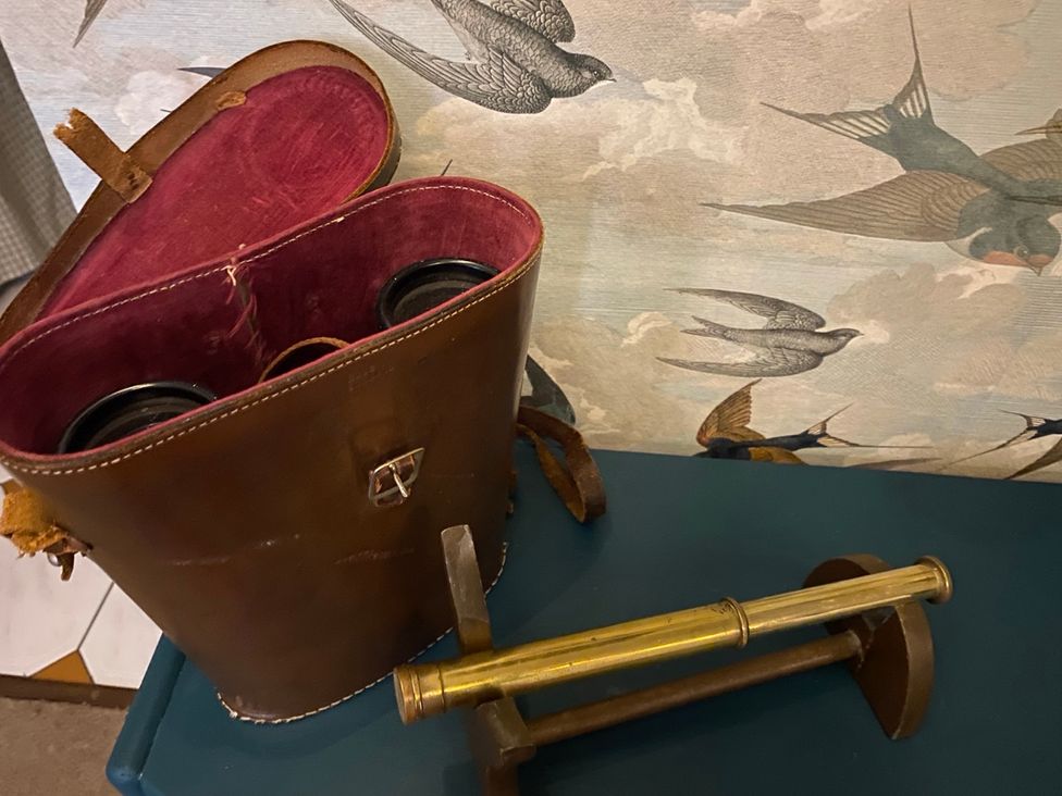 A leather case with binoculars and a brass stand at Corner Cottage in Lowick Green near Ulverston