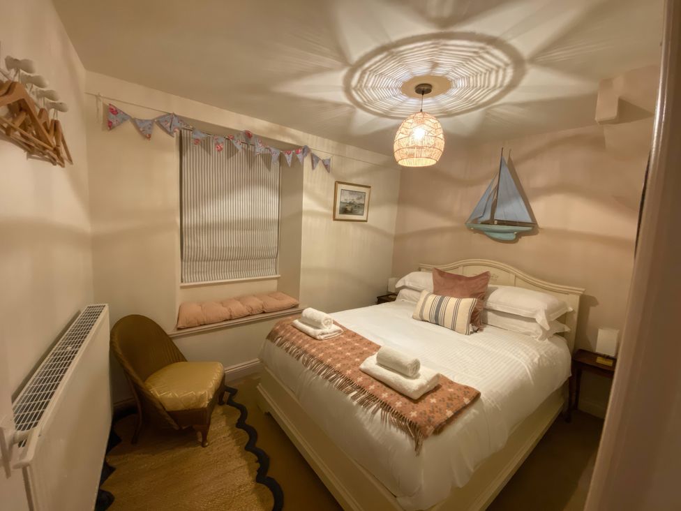 A bedroom with a bed and wall decorations at Corner Cottage in Lowick Green near Ulverston