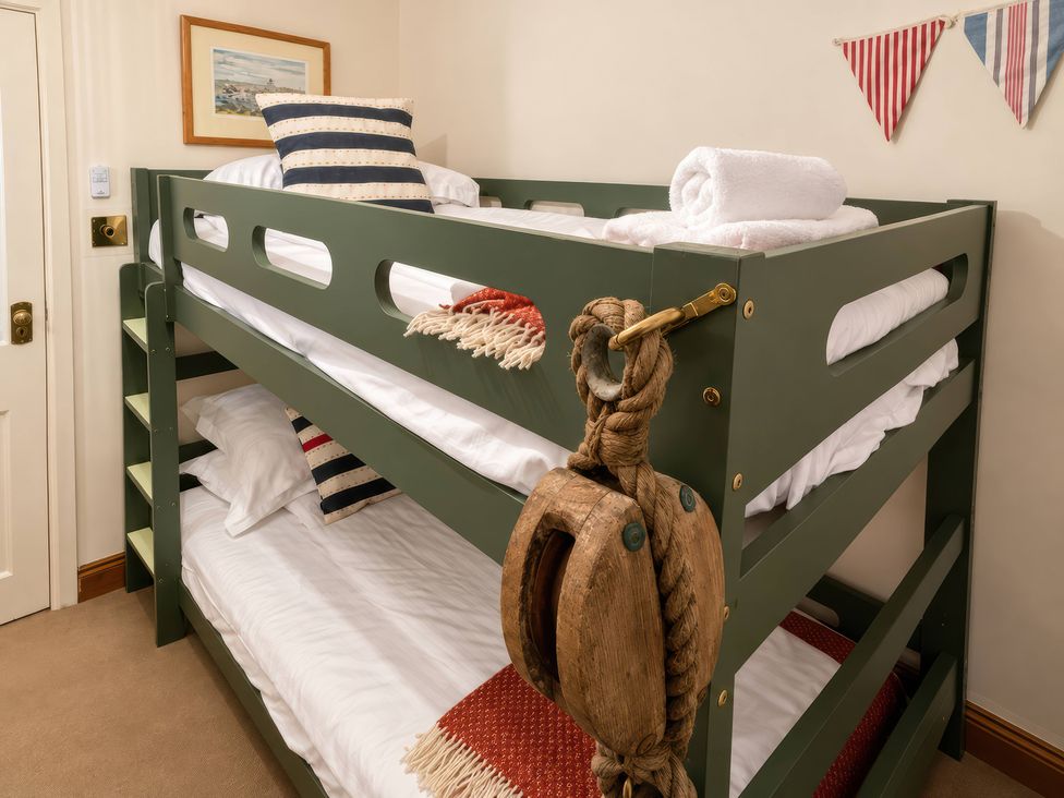 A bunk bed with towels and a decorative pulley at Corner Cottage in Lowick Green near Ulverston