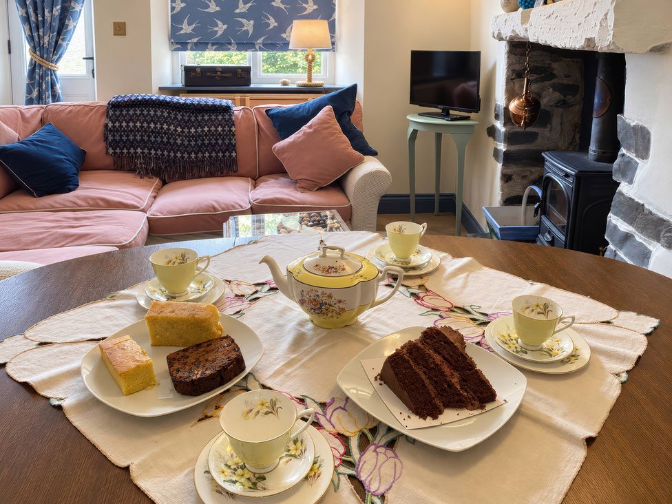 A living room with a table set for tea at Corner Cottage Lowick Green near Ulverston