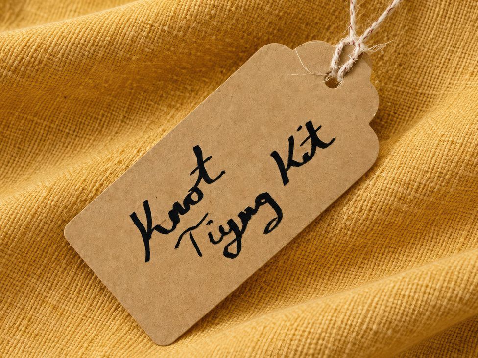A tag labeled as Knot Tying Kit on yellow fabric