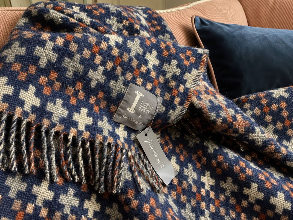 A blanket with tags on a sofa at Corner Cottage Lowick Green near Ulverston