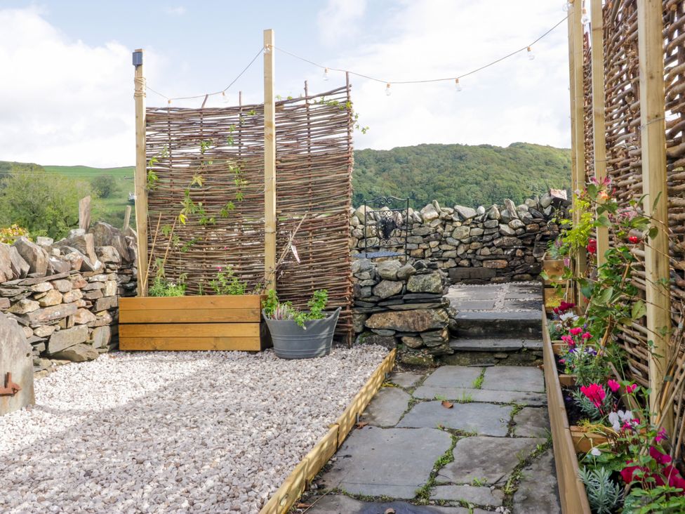 A garden with gravel and a stone wall at Corner Cottage Lowick Green near Ulverston