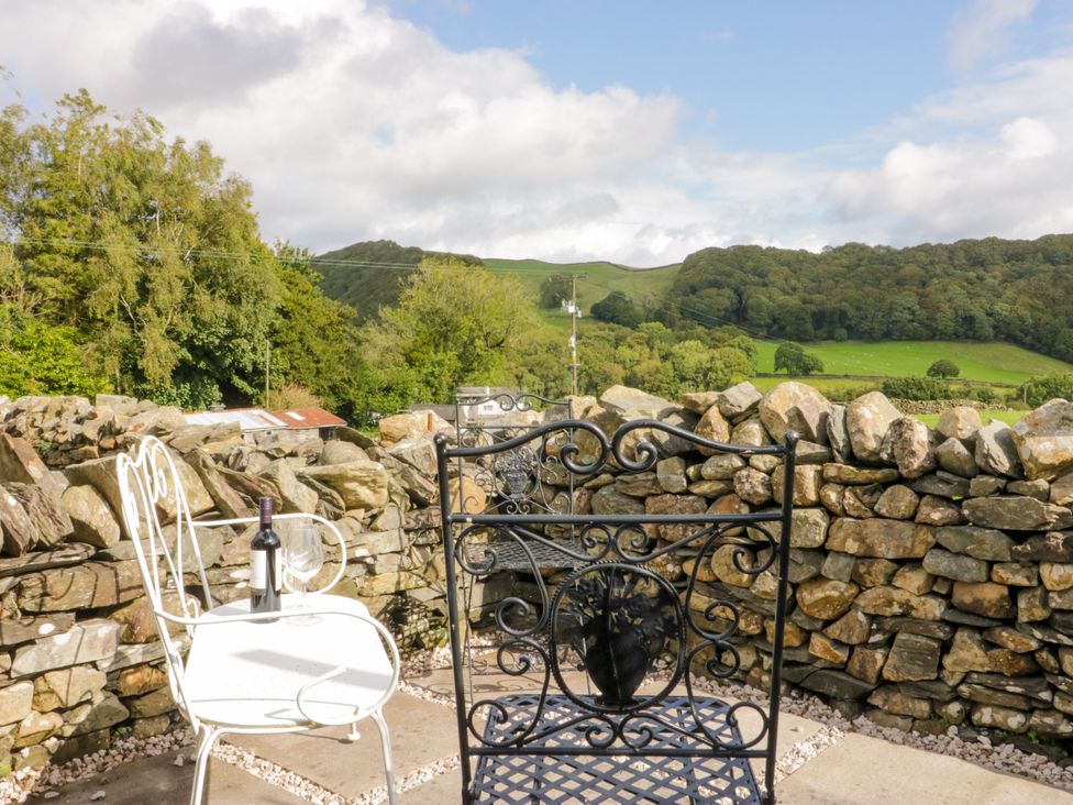 An outdoor seating area with a table and chairs at Corner Cottage Lowick Green near Ulverston