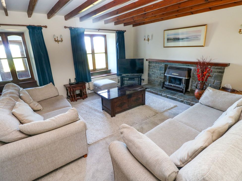 A living room with a television and fireplace at Park Hall Cottage in Solva