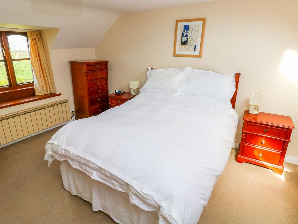 A bedroom with a bed and bedside tables at Park Hall Cottage in Solva