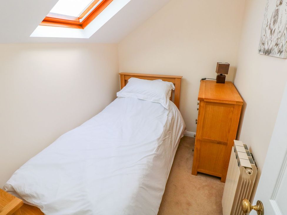 A bedroom with a single bed and a nightstand at Park Hall Cottage in Solva
