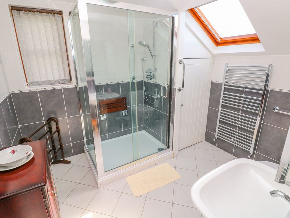 A bathroom with shower and bathtub at Park Hall Cottage in Solva
