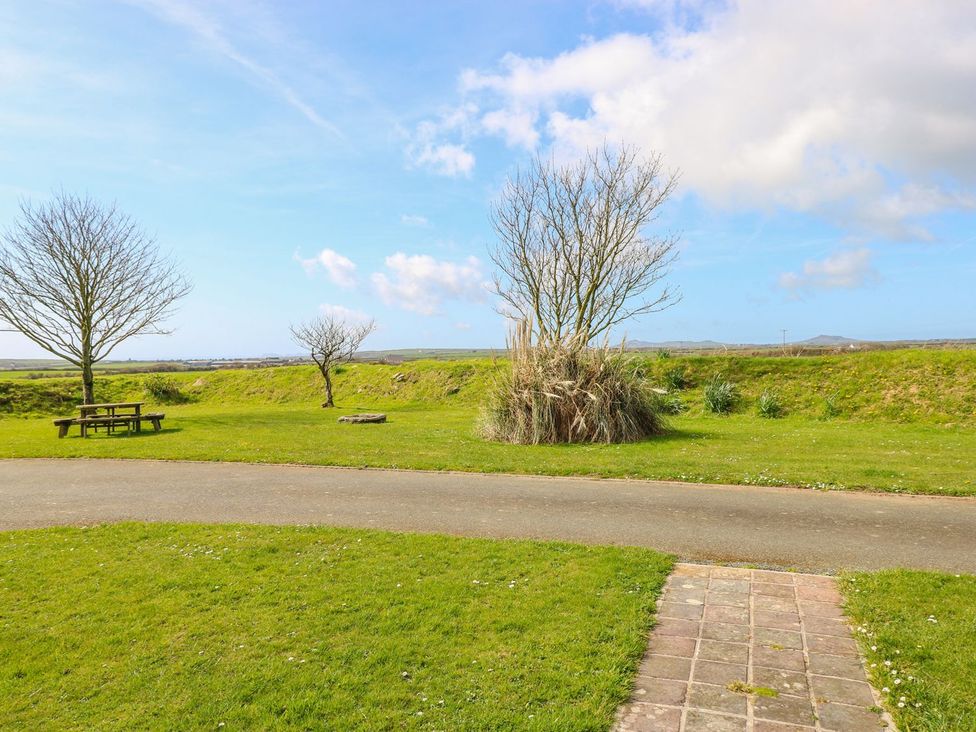 An outdoor area with a picnic table and trees at Park Hall Cottage, Solva
