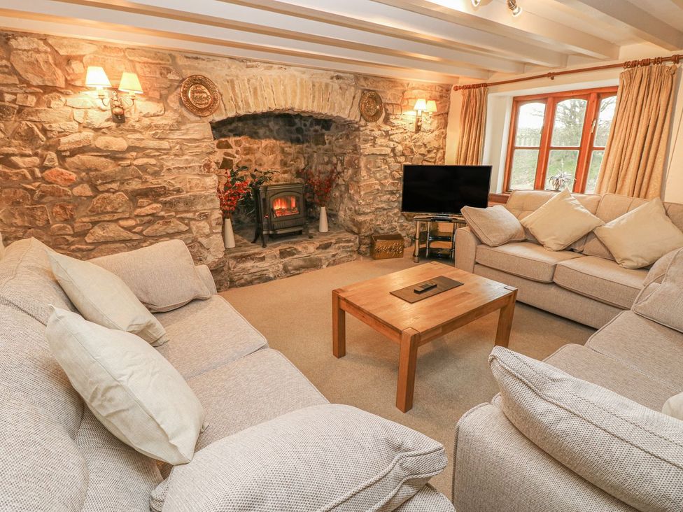 A living room with a sofa and a coffee table at Maerdy Lodge