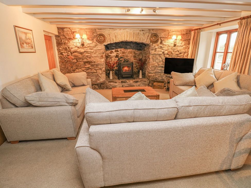 A living room with sofa and fireplace at Maerdy Lodge