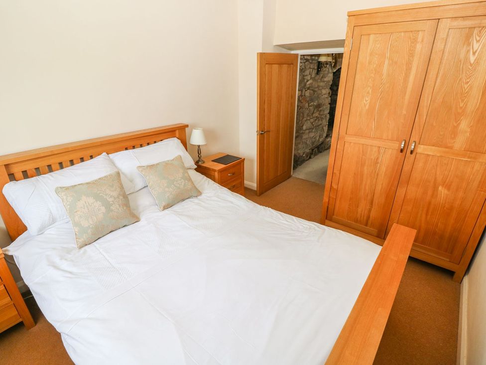 A bedroom with a bed and wooden wardrobe at Maerdy Lodge 