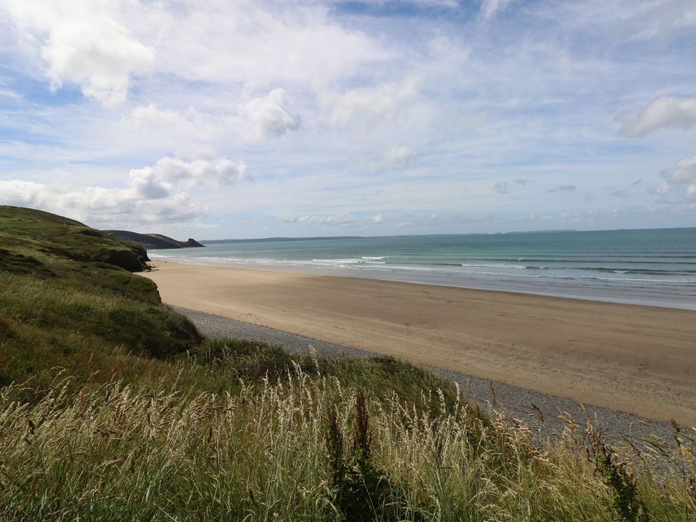 A beach view with grass in the foreground at Maerdy Lodge in 