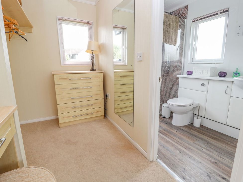 A bathroom with a shower and sink at Honeysuckle Lodge in Towyn