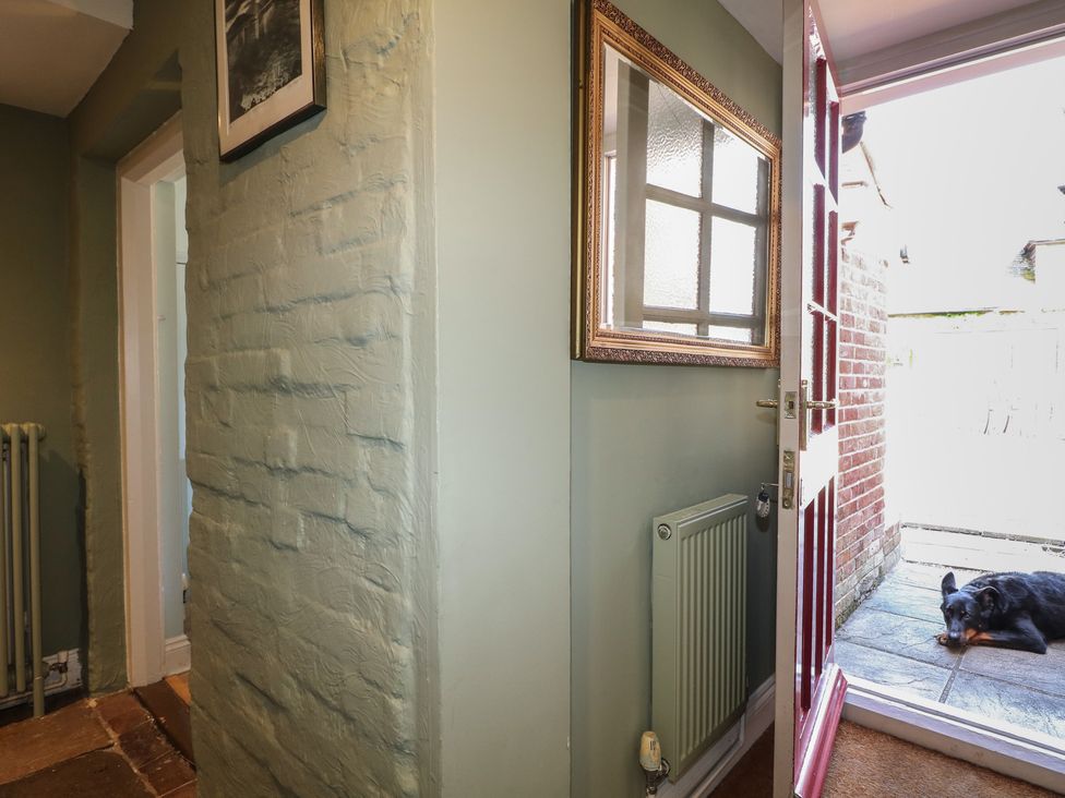 A hallway with a door and radiator at The Old School House in Chichester