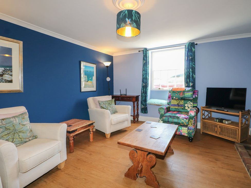 A living room with a sofa, armchair, and tv at The Old School House in Chichester