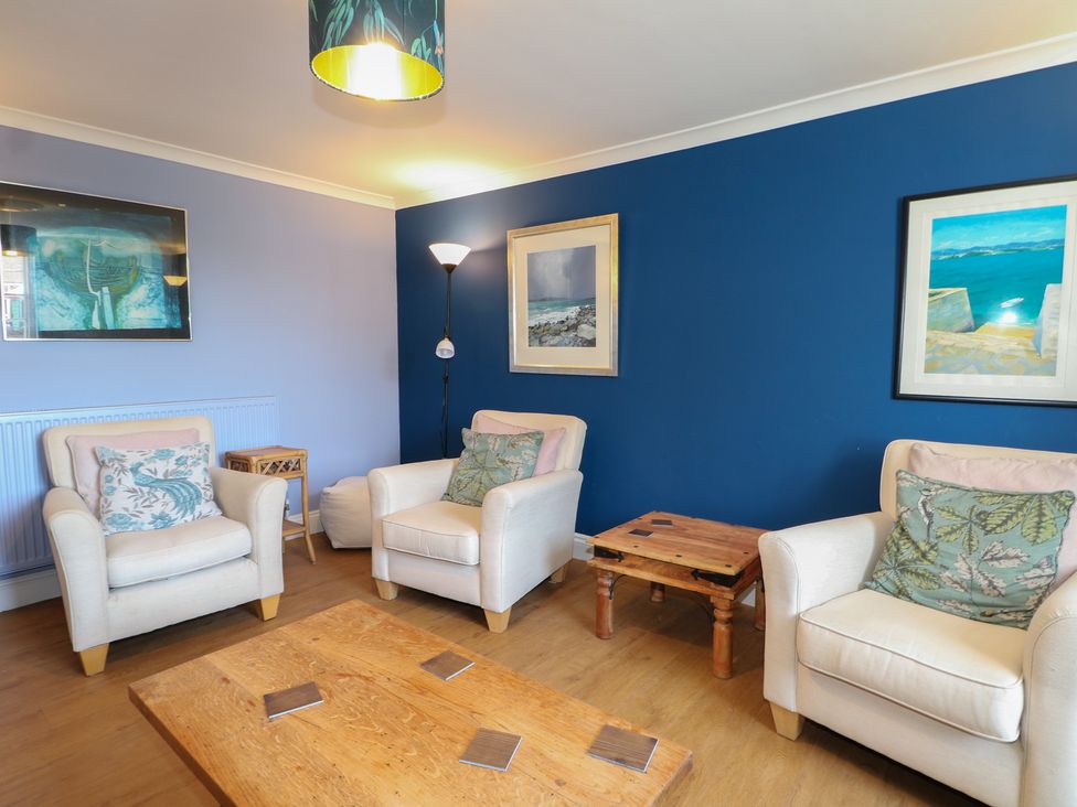 A living room with seating and art on the wall at The Old School House in Chichester