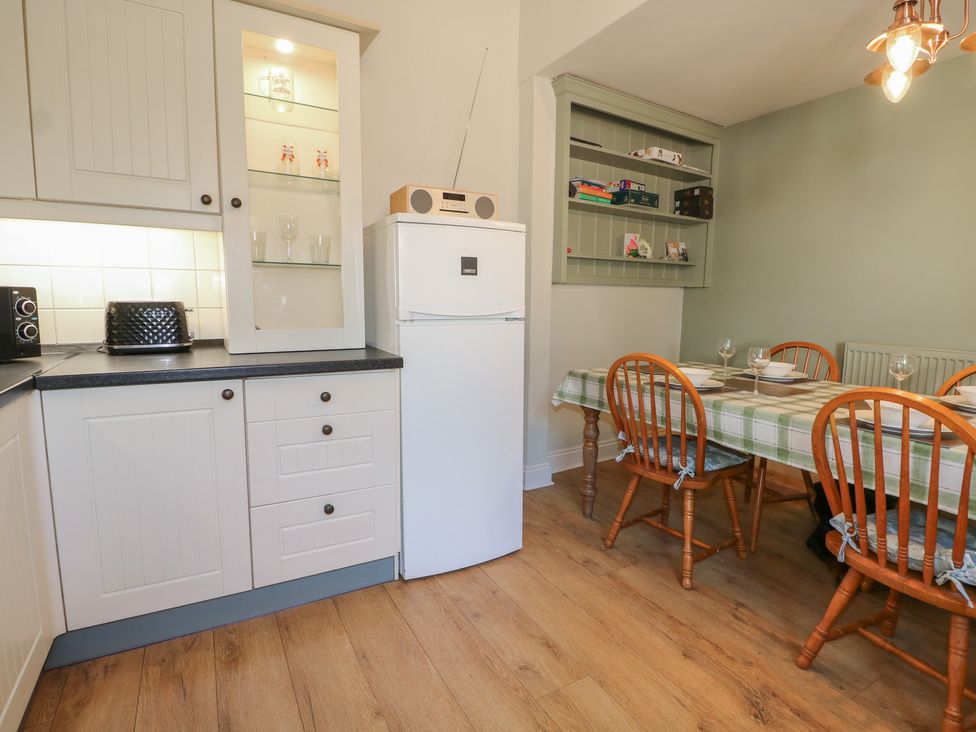 A kitchen with a dining area and appliances at The Old School House in Chichester