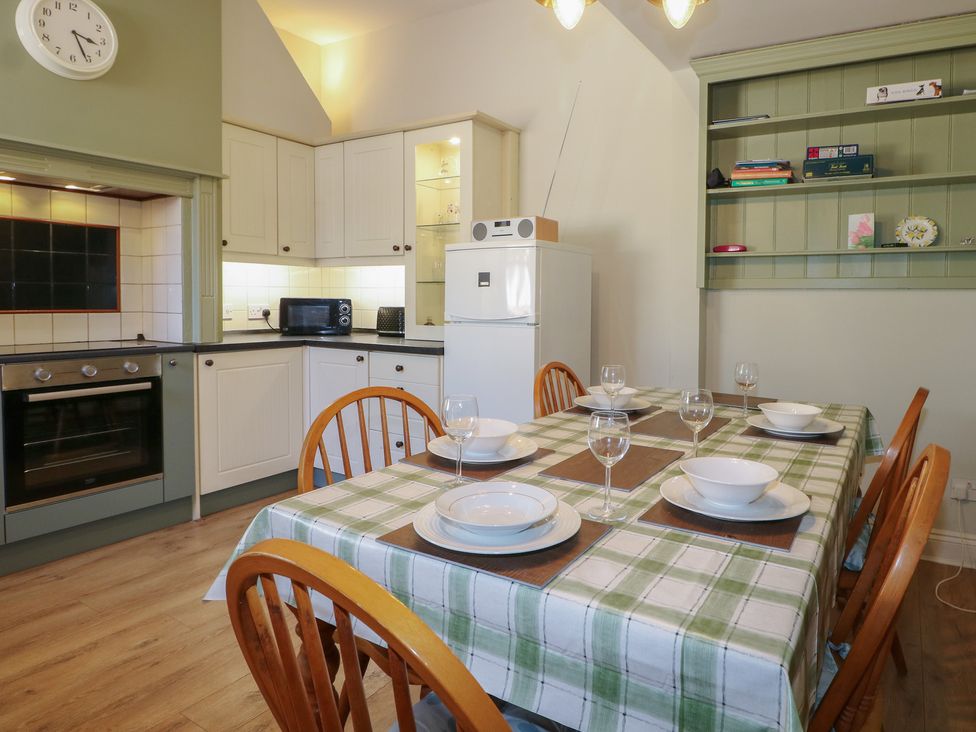 A kitchen with dining table set for four at The Old School House in Chichester