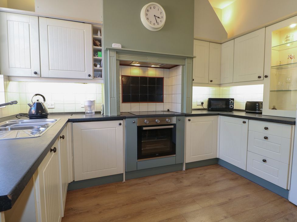 A kitchen with cabinets and appliances at The Old School House in Chichester