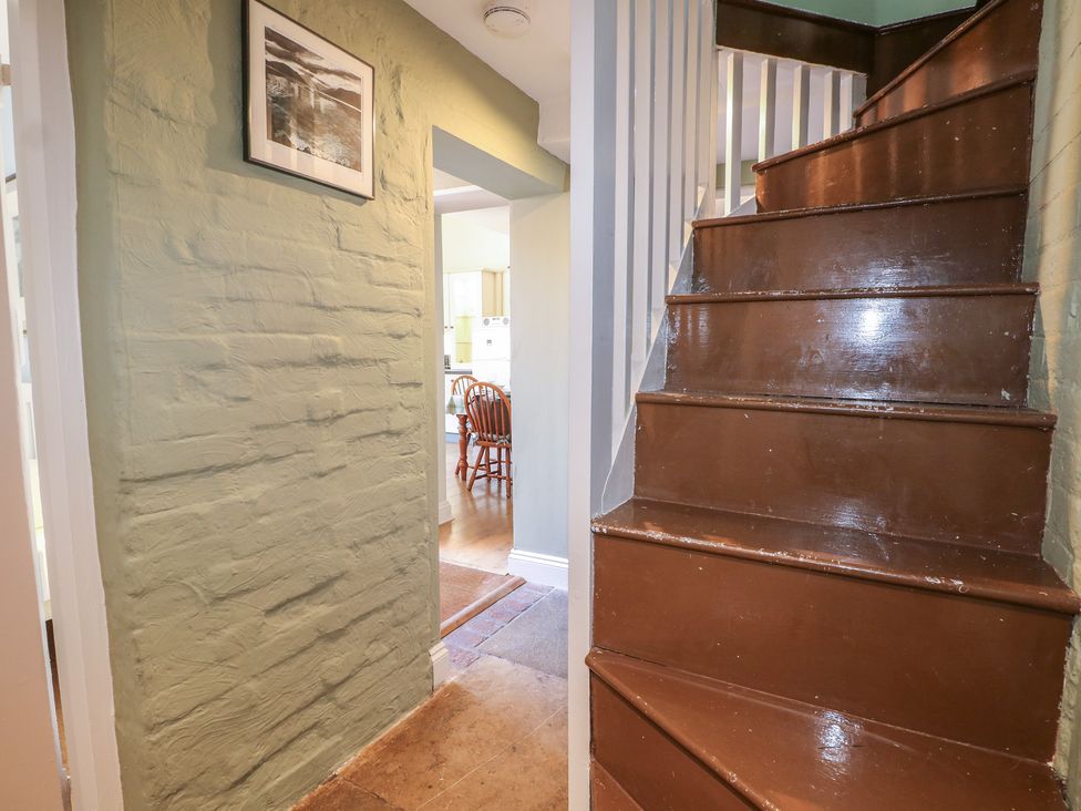A hallway with a staircase and doorway at The Old School House in Chichester