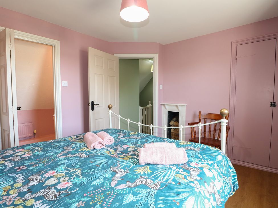 A bedroom with a bed and towels at The Old School House in Chichester