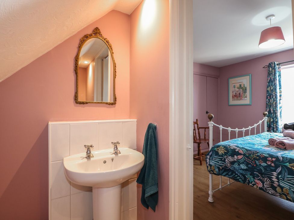 A bedroom with a sink and mirror at The Old School House in Chichester