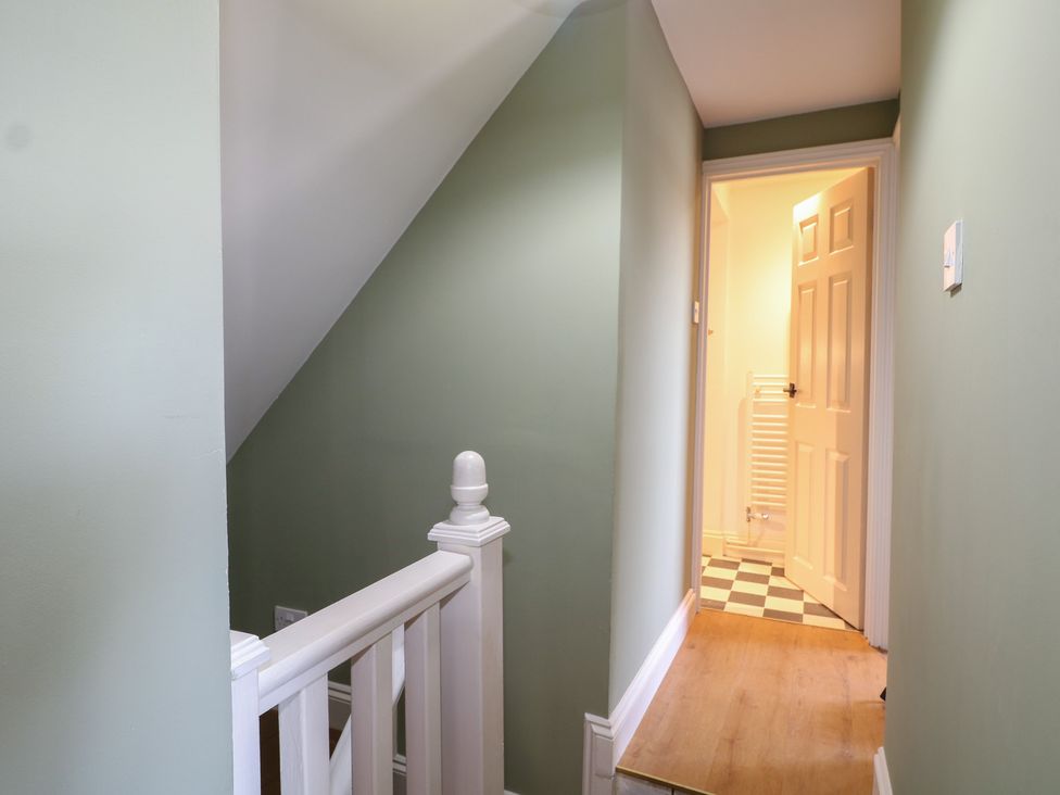 A hallway with staircase and door leading to another room at The Old School House in Chichester