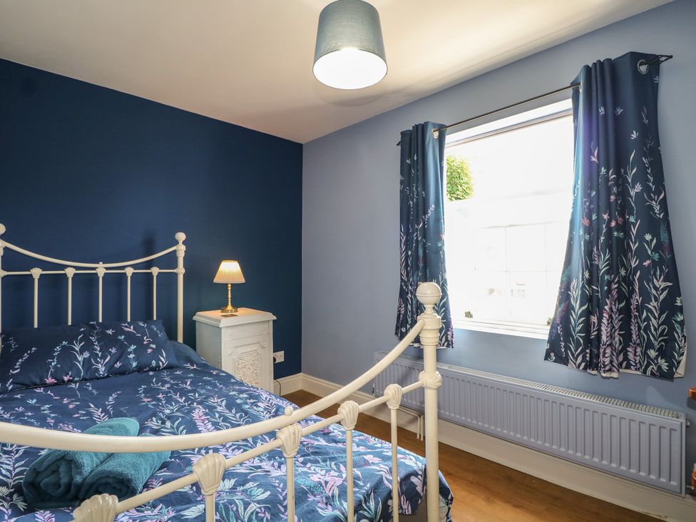 A bedroom with a bed and lamp at The Old School House in Chichester