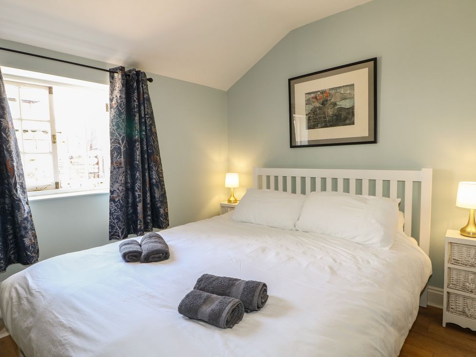 A bedroom with a bed and towels on it at The Old School House in Chichester