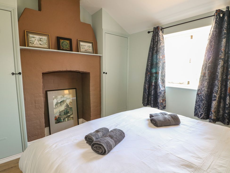 A bedroom with a bed and towels on it at The Old School House in Chichester