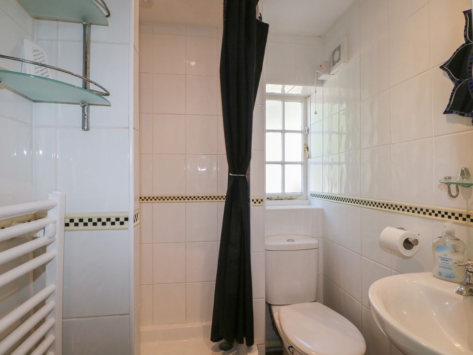 A bathroom with a shower curtain and toilet at The Old School House in Chichester