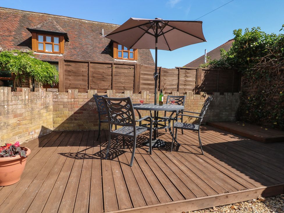 A garden with a table and chairs under an umbrella at The Old School House in Chichester
