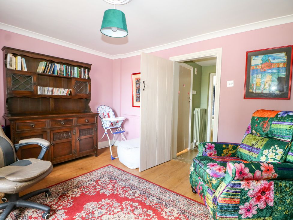 A living room with a bookshelf and a recliner chair at The Old School House in Selsey