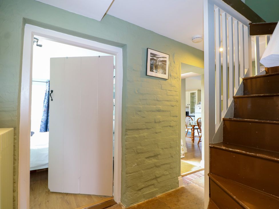 A hallway with a door leading to a room and stairs at The Old School House in Selsey