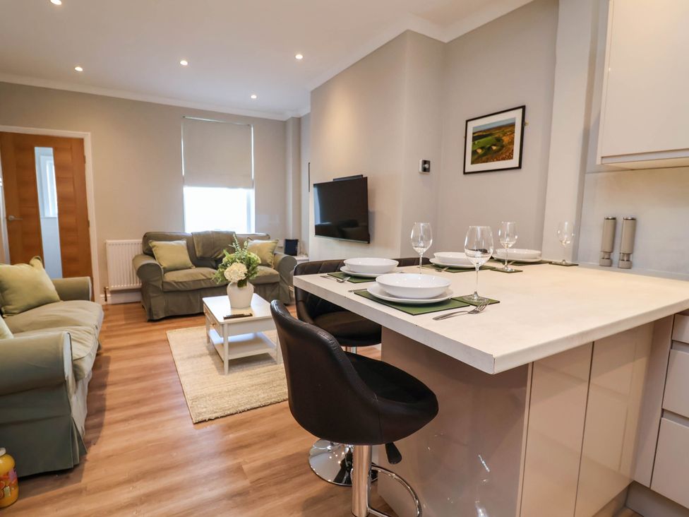 A living room with sofa and dining area at Brightside in Hoylake