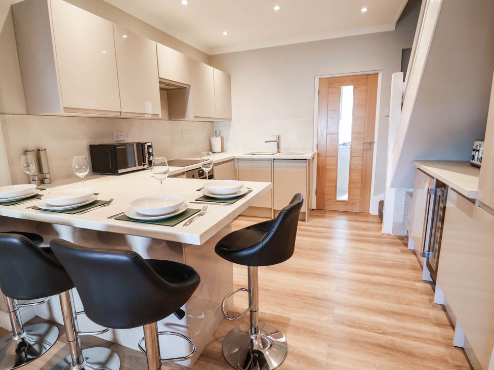 A kitchen with bar stools and a table at Brightside in Hoylake