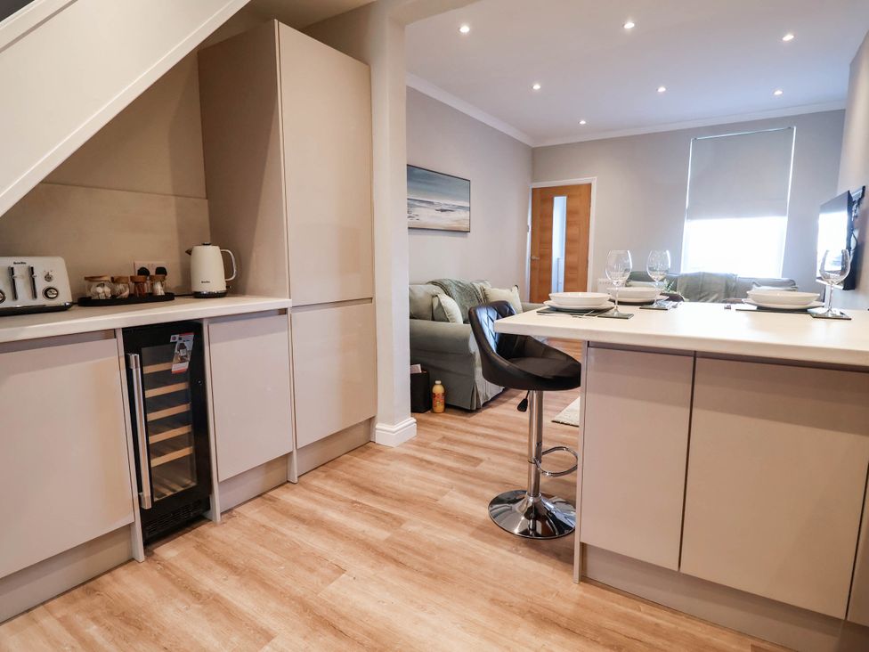 A kitchen with a bar stool and dining setup at Brightside in Hoylake