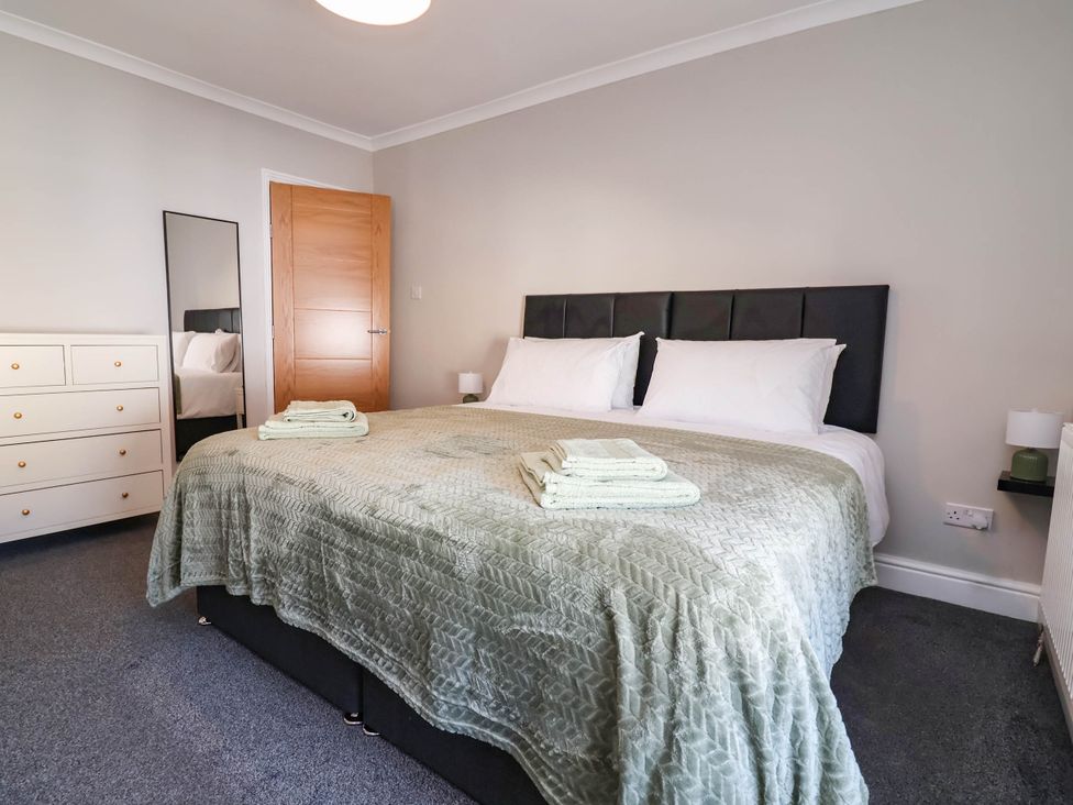 A bedroom with a double bed and dresser at Brightside in Hoylake