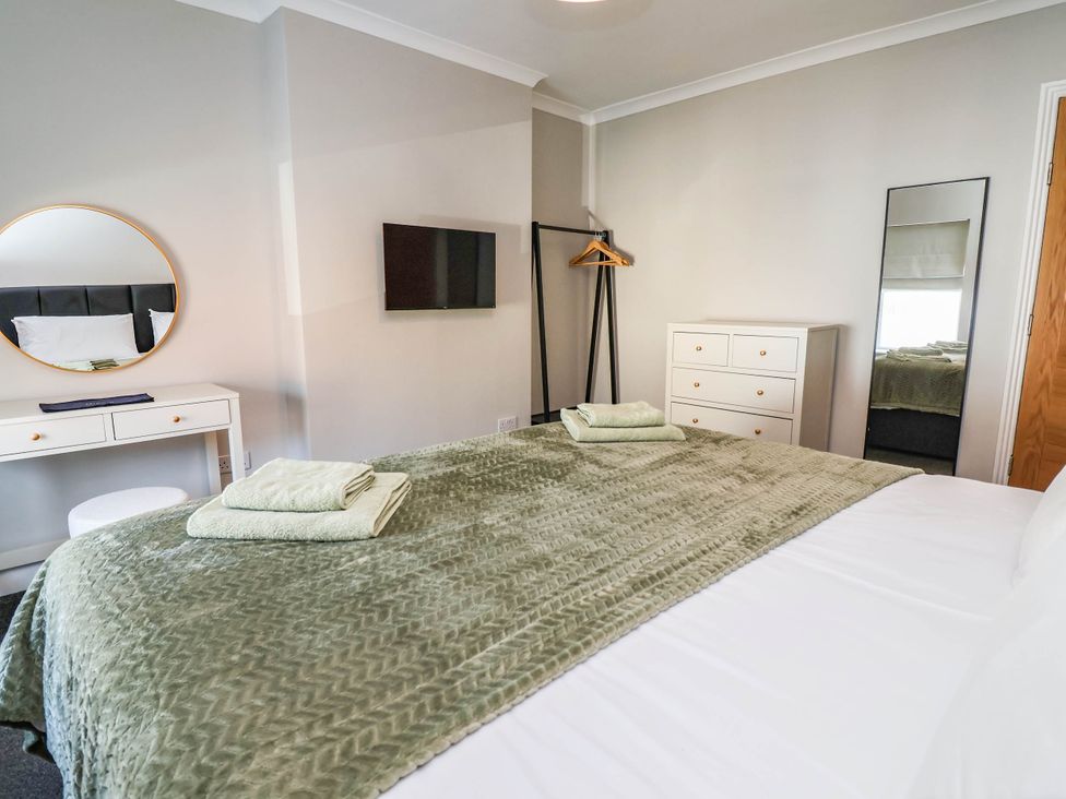 A bedroom with a bed and dresser at Brightside in Hoylake
