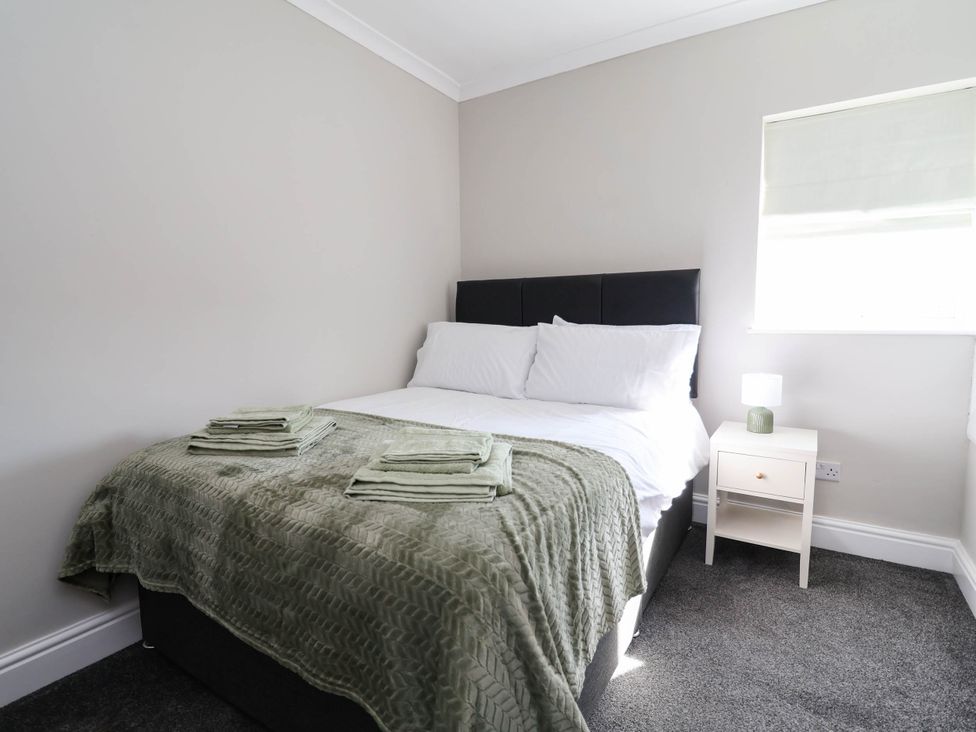 A bedroom with a bed and nightstand at Brightside in Hoylake