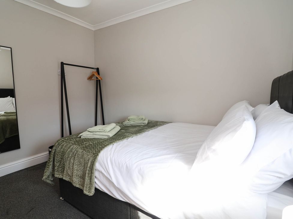 A bedroom with a bed and towels at Brightside in Hoylake