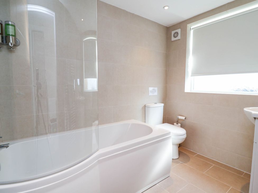A bathroom with a bath tub and toilet at Brightside in Hoylake