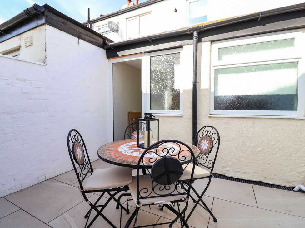 An outdoor seating area with a table and chairs at Brightside in Hoylake