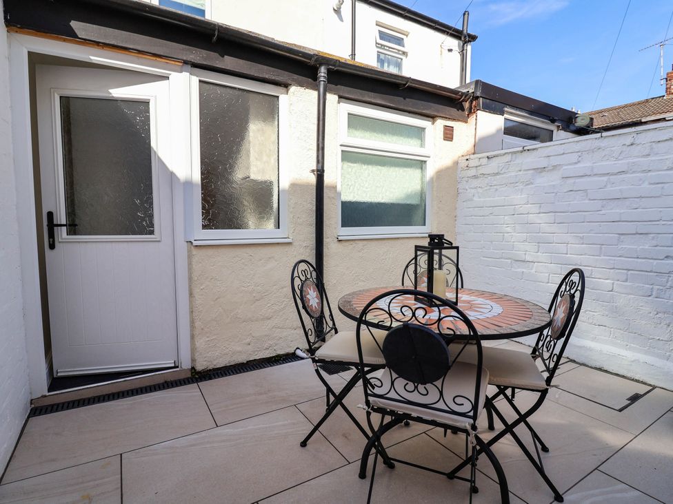An outdoor seating area with a table and chairs at Brightside in Hoylake