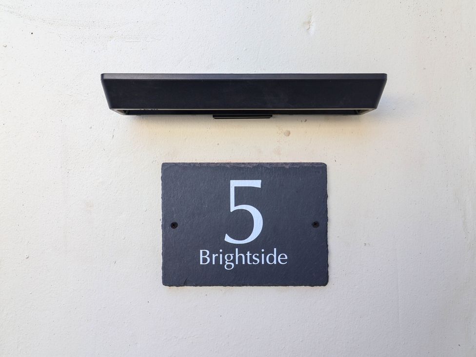 A house number sign and light fixture at Brightside in Hoylake